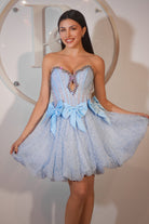 Woman in light blue party dress with bows.