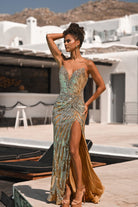 Woman in gold sequin gown with high slit.
