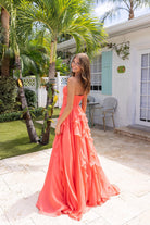 Coral dress, XO170-Coral-03, woman in front of a house.