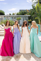 Four women in fuchsia, periwinkle, champagne, and mint gowns