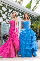 Two women in pink and teal ruffle gowns