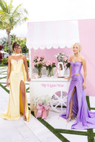 Two women in elegant dresses by a cart.